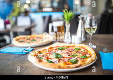 The served dinner table with pizza in pizzeria or  restaurant. Stock Photo
