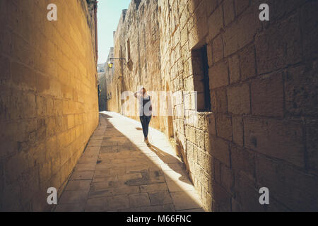 Narrow streets of the old Mdina. Tourist walking. Typical architecture in Malta Stock Photo