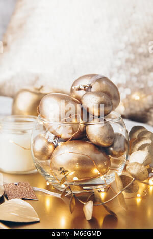 Close-up of golden eggs, candle and decorations on a tray Stock Photo