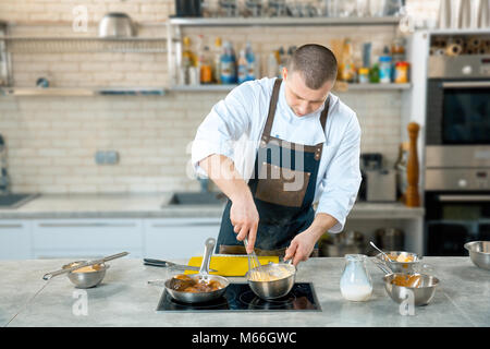 Focused chef preparing a polenta in the restaurant kitchen. cooking process Stock Photo