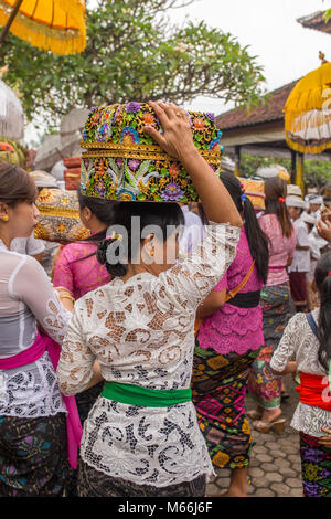 Bali, Indonesia - September 17, 2016: Unidentified balinese woman in traditional dress sarong with religious offering during Galungan celebration in B Stock Photo