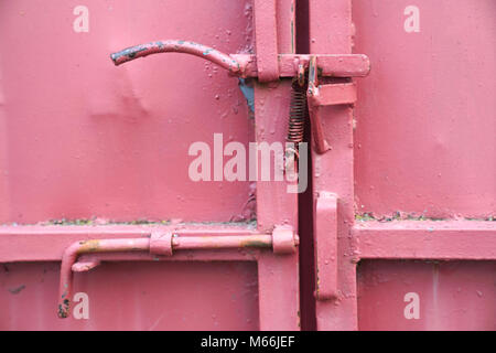Detailed latch and handle on a red iron door Stock Photo