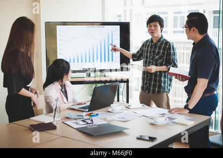 Asian businesswoman discussing and brainstorm with young freelance man in meeting room. Business company co-operate with outsource worker concept. Stock Photo