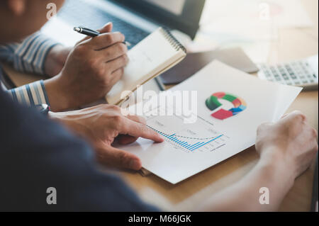 Businessman hand holding report document in office meeting room with business discussion and brainstorm atmosphere in blurry background. Stock Photo