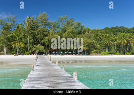 Wooden pier to a tropical island beach on Koh Kood island during day time, Thailand. Stock Photo
