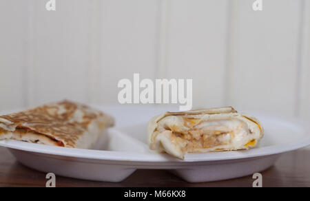 A pair of warm, toasted burritos served on a divided plate Stock Photo