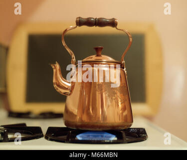 COPPER TEA KETTLE ON GAS FLAME - kh13267 CPC001 HARS OLD FASHIONED Stock Photo