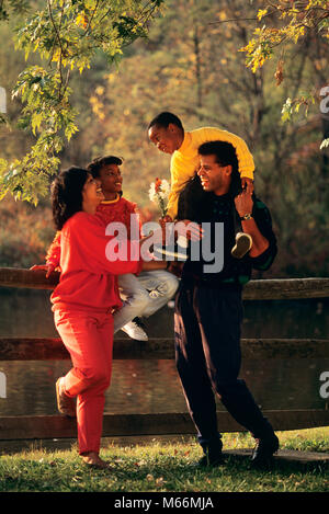 1990s AFRICAN AMERICAN FAMILY STANDING BY FENCE IN AUTUMN BOY HANDING FLOWERS TO MOTHER - kj12498 DEG002 HARS STAND PRESENT FOUR AUTUMN MOM RACE NOSTALGIC 4 YELLOW DIVERSITY COLOR RELATIONSHIP MOTHERS OLD TIME BROTHER GROWN OLD FASHION SISTER BOUQUET GIVING JUVENILE LAUGH POND SONS JOY LIFESTYLE PARENTING FEMALES BROTHERS RELATION RURAL HUSBANDS HOME LIFE COPY SPACE PEOPLE CHILDREN FRIENDSHIP FULL-LENGTH DAUGHTERS RACIAL SIT STREAM CARING HANDING SIBLINGS CONFIDENCE AMERICANS GIVE SISTERS FAMILIES NOSTALGIA FATHERS HUSBAND AND WIFE DAISY BOND TOGETHERNESS 25-30 YEARS 30-35 YEARS 7-9 YEARS Stock Photo