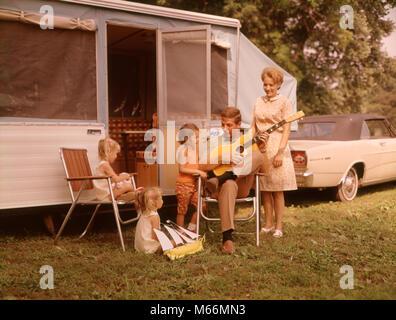 1960s FAMILY VACATION RV POP-UP CAMPER MOTHER THREE CHILDREN ALL GIRLS FATHER SITTING PLAYING GUITAR - km1524 HAR001 HARS RELATIONSHIP MOTHERS OLD TIME OLD FASHION SISTER JUVENILE COMMUNICATION BLOND VACATION CAUCASIAN LIFESTYLE SOUND FIVE PARENTING FEMALES MARRIED 5 RURAL SPOUSE HUSBANDS GROWNUP HEALTHINESS COMMUNICATING COPY SPACE FRIENDSHIP HALF-LENGTH LADIES DAUGHTERS GROWN-UP ENTERTAINMENT SIBLINGS SISTERS TRANSPORTATION FAMILIES NOSTALGIA FATHERS PATERNAL TOGETHERNESS 25-30 YEARS 3-4 YEARS 30-35 YEARS TIME OFF 5-6 YEARS FATHERHOOD MATERNAL YOUNGSTER WIVES HAPPINESS ADVENTURE LEISURE MOMS Stock Photo