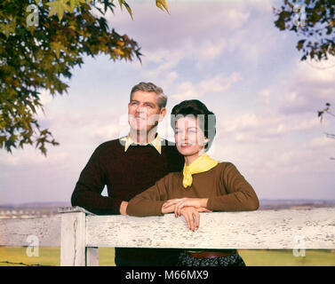 1950s 1960s SMILING MIDDLE AGE COUPLE OUTDOORS IN AUTUMN LEANING ON FENCE MAN WOMAN COUPLES MEN WOMEN - kp574 HAR001 HARS HEALTHINESS HOME LIFE COPY SPACE FRIENDSHIP HALF-LENGTH LADIES GROWN-UP COUPLES NOSTALGIA MIDDLE-AGED TOGETHERNESS 35-40 YEARS 40-45 YEARS STRUCTURE WIVES HAPPINESS STYLES FALL SEASON CONNECTION FASHIONS MALES MID-ADULT MID-ADULT MAN MID-ADULT WOMAN PEOPLE ADULTS CAUCASIAN ETHNICITY OLD FASHIONED PERSONS Stock Photo