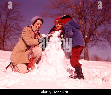 1970s SMILING WOMAN MOTHER TWO BOYS SONS BUILDING SNOWMAN TOGETHER - kw5453 HAR001 HARS BUSY BROTHER OLD FASHION 1 JUVENILE TEAMWORK CAUCASIAN SNOWMAN PLEASED JOY LIFESTYLE PARENTING FEMALES BROTHERS GROWNUP PEOPLE CHILDREN FULL-LENGTH LADIES PHYSICAL FITNESS GROWN-UP SIBLINGS NOSTALGIA TOGETHERNESS WINTERTIME 25-30 YEARS 30-35 YEARS WINTER SEASON 5-6 YEARS MATERNAL YOUNGSTER STRUCTURE CHEERFUL MOMS PARENTHOOD EXCITEMENT RECREATION PARENTAL SIBLING SMILES JOYFUL MOTHERHOOD COOPERATION SMALL GROUP OF PEOPLE JUVENILES MALES MID-ADULT MID-ADULT WOMAN CAUCASIAN ETHNICITY OLD FASHIONED PERSONS Stock Photo