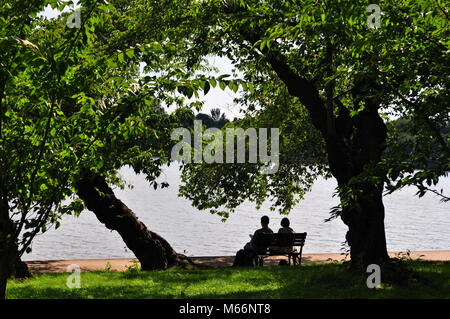 Young couple sitting on a bench with a view Stock Photo