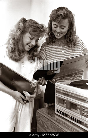 1980s 2 TEENAGE GIRLS READING VINYL RECORD ALBUM JACKET COVERS LISTENING TO LONG PLAYING PHONOGRAPH PLAYER - m11308 HAR001 HARS NOSTALGIA PLAYERS PHONOGRAPH TOGETHERNESS STEREO 13-15 YEARS 16-17 YEARS COOPERATION COMMUNICATE SLEEVES TEENAGED LP JUVENILES ALBUMS B&W BLACK AND WHITE CAUCASIAN ETHNICITY JACKETS OLD FASHIONED PERSONS RECORDINGS Stock Photo