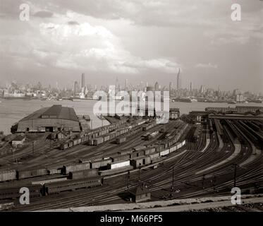 1940s NEW YORK CITY MANHATTAN MIDTOWN SKYLINE FROM RAILROAD YARD IN NEW JERSEY USA - r1523 HAR001 HARS B&W BLACK AND WHITE EMPIRE STATE BUILDING HUDSON RIVER OLD FASHIONED SKYSCRAPERS TRAIN YARD Stock Photo