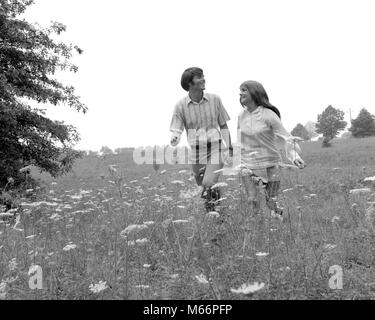 1970s COUPLE HOLDING HANDS WALKING IN HIGH FIELD WITH QUEEN ANNE'S LACE - r22343 HAR001 HARS OLD FASHION YOUNG ADULT LOVERS TEAMWORK TWO PEOPLE CAUCASIAN PLEASED JOY LIFESTYLE FEMALES RURAL GROWNUP HEALTHINESS NATURE COPY SPACE FRIENDSHIP HALF-LENGTH LADIES ADOLESCENT CARING TEENAGE GIRL TEENAGE BOY COUPLES CONFIDENCE HIKE NOSTALGIA TOGETHERNESS 20-25 YEARS RELEASES FREEDOM PEOPLE STORY HAPPINESS HOBBY AND EXCITEMENT HIKER HOBBIES 18-19 YEARS DIRECTION HOLDING HANDS LOVING ROMANCING ROMANTICS SMILES STROLLING CONNECTION JOYFUL ROMANCES COOPERATION TEENAGED HIKES QUEEN ANNE'S LACE HIKERS LOVER Stock Photo
