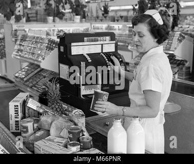 1950s WOMAN GROCERY SUPERMARKET CASHIER RINGING FOOD PURCHASES - s5483 HAR001 HARS FEMALES JOBS ONE PERSON ONLY UNITED STATES HALF-LENGTH LADIES UNITED STATES OF AMERICA INDOORS NOSTALGIA NORTH AMERICA 40-45 YEARS 45-50 YEARS SKILL OCCUPATION SKILLS PRICE HIGH ANGLE RINGING CUSTOMER SERVICE MILK BOTTLE MID-ADULT MID-ADULT WOMAN B&W BLACK AND WHITE CAUCASIAN ETHNICITY CHECK OUT MANUAL CASH REGISTER OCCUPATIONS OLD FASHIONED PERSONS PURCHASES Stock Photo