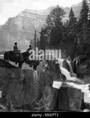 1920s 1930s COUPLE MAN WOMAN ON HORSES BY WATERFALL IN PINE FOREST GIANTS STEPS PARADISE VALLEY ALBERTA CANADA - w2592 HAR001 HARS HUSBANDS NATURE COPY SPACE FRIENDSHIP FULL-LENGTH LADIES SCENIC INSPIRATION SADDLE RISK WESTERN ANIMALS COUPLES ROUGH SPIRITUALITY NOSTALGIA TOGETHERNESS 25-30 YEARS 30-35 YEARS 35-40 YEARS FREEDOM HORSEBACK WIVES HAPPINESS TWO ANIMALS MAMMALS ADVENTURE DISCOVERY WATERFALL RELAXATION RECREATION ROCKS WILDERNESS GIANTS PARADISE CANADIAN ROCKIES RUGGED TRAIL RIDING ALBERTA INSPIRING MALES MAMMAL MID-ADULT MID-ADULT MAN MID-ADULT WOMAN REMOTE B&W BLACK AND WHITE Stock Photo