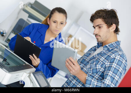 male maintenance engineer showing digital tablet to colleague Stock Photo