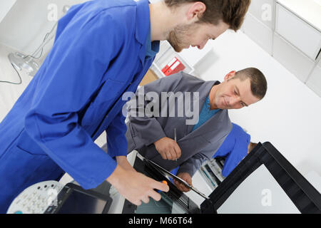 apprentice fixing a printer Stock Photo