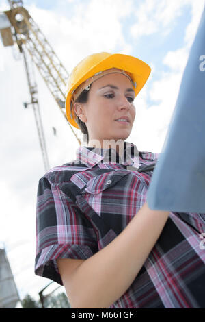 female engineer holding construction plans Stock Photo