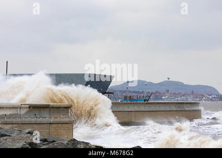 Colwyn Bay, UK UK Weather. The Beast from the East covers many parts of the UK with snow with further snowfall to arrive today with Met Office Red Warnings in place for snow and winds. Freezing temperatures and high winds bringing coastal flooding to the seafront at Colwyn Bay as huge waves crash into the coastal wall and Porth Eirias building on the promenade as a result of Storm Emma and the Beast from the East storm front Stock Photo
