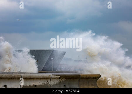 Colwyn Bay, UK UK Weather. The Beast from the East covers many parts of the UK with snow with further snowfall to arrive today with Met Office Red Warnings in place for snow and winds. Freezing temperatures and high winds bringing coastal flooding to the seafront at Colwyn Bay as huge waves crash into the coastal wall and Porth Eirias building on the promenade as a result of Storm Emma and the Beast from the East storm front Stock Photo