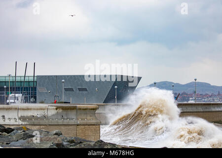 Colwyn Bay, UK UK Weather. The Beast from the East covers many parts of the UK with snow with further snowfall to arrive today with Met Office Red Warnings in place for snow and winds. Freezing temperatures and high winds bringing coastal flooding to the seafront at Colwyn Bay as huge waves crash into the coastal wall and Porth Eirias building on the promenade as a result of Storm Emma and the Beast from the East storm front Stock Photo