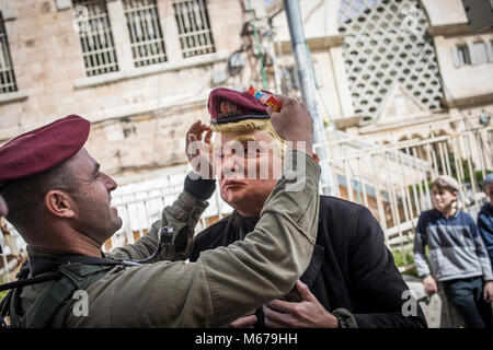 An Israeli soldier places a hat on an Israeli settler costumed as US President Trump during a parade marking the Jewish holiday of Purim in the divided West Bank city of Hebron, 01 March 2018. The carnival-like Purim holiday is celebrated with parades and costume parties to commemorate the deliverance of the Jewish people from a plot to exterminate them in the ancient Persian empire 2,500 years ago, as recorded in the Biblical Book of Esther. Photo: Ilia Yefimovich/dpa Stock Photo