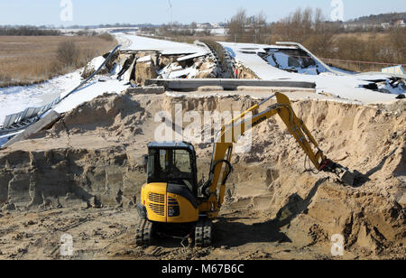 An excavator removing earth from the sunken Baltic Sea autobahn A20 near Tribsees, Germany, 01 March 2018. Federal Transportation Minister Schmidt has promised Mecklenburg-Western Pomerania comprehensive support with the repair work. Unterstützung bei der Reparatur zugesagt. The A20 is completely shut down since end of October 2017 after collapses in the road's surface. Photo: Bernd Wüstneck/dpa Stock Photo