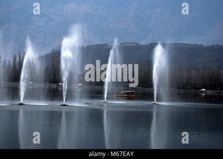 March 1, 2018 - Srinagar, India - A boatman rows past water fountains in Dal Lake on a cloudy day in Srinagar..Meteorological department has predicted moderate rain and snow across Kashmir for next three days from Thursday onwards to Sunday forenoon. (Credit Image: © M SAQIB010318  1 .jpg/SOPA Images via ZUMA Wire) Stock Photo