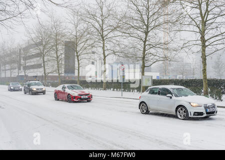 Southampton, UK. 1st of March 2018. Heavy snow has caused the University of Southampton (England, UK) to shut down for business for the rest of the day as well as tomorrow due to adverse and hazardous weather conditions. Pictured here, are cars driving slowly along University Road at Highfield Campus during heavy snowfall. Stock Photo
