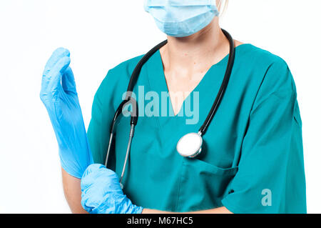 Nurse wearing surgical mask putting on latex gloves Stock Photo - Alamy