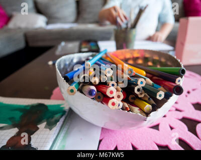 Bunch of wooden colors close up and kid painting at background Stock Photo
