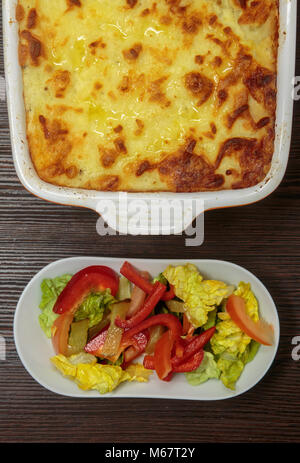 Shepherd's pie or cottage pie is a meat pie with a crust of mashed potato. The defining ingredients are minced meat, typically vegetables. Stock Photo