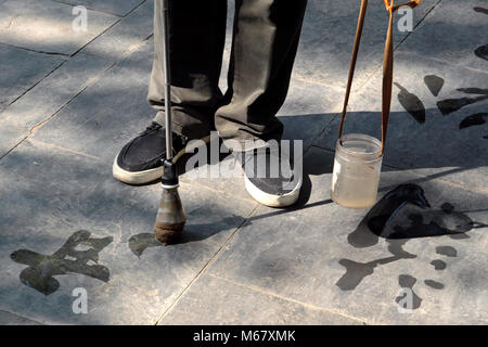 Old man - calligrapher - practicing traditional pavement water calligraphy, The Summer Palace, Beijing, China Stock Photo