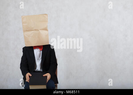 Boy of four years old with covered head is sitting on a chair. Free space for a text. Stock Photo