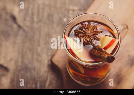 hot spicy beverage. Hot drink (apple tea, punch) with cinnamon stick and star anise. Seasonal mulled drink. Stock Photo