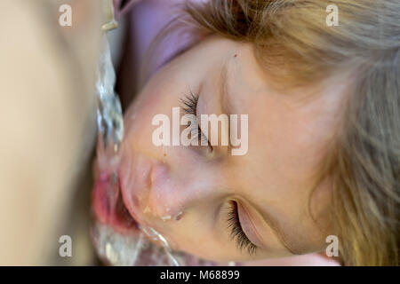 Young child drinking water from a fountain Stock Photo