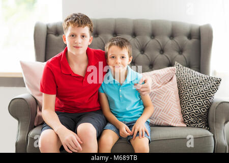 Older brother on the sofa hugging younger brother. Family portrait Stock Photo