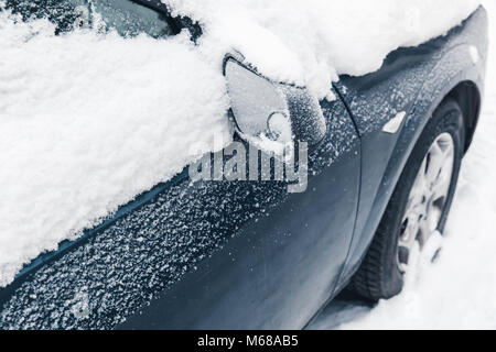 Car mirror covered with snow in cold winter Stock Photo