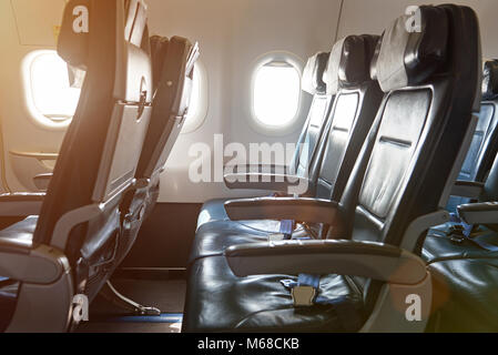 Row of leather seats in airplane interior. Side view of air plane chairs Stock Photo