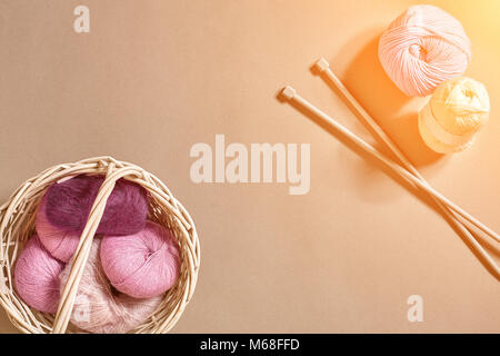 Balls of woolen threads and knitting needles. Scandinavian style. Threads for knitting in a basket. Sun flare Stock Photo