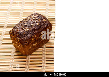 Toasty Organic Loaf of rye Bread on wooden plank isolated on white. Stock Photo
