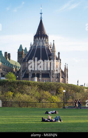 People enjoying a sunny spring day on Major's Hill Park with the Library of Parliament in the background Stock Photo