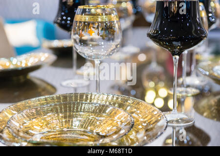 Close up of glamorous table service, black and with a golden rim posh glasses and plates Stock Photo