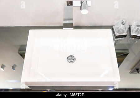 Modern square washbasin mounted in a mirror surface. Concept of home interior Stock Photo