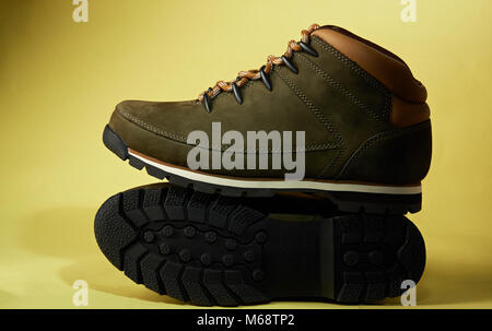 Pair of modern hiking shoes isolated on yellow background. New pair of hike boots Stock Photo