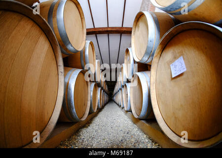 Wine barrels stacked in old winery cellar Stock Photo
