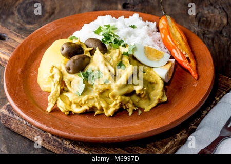 MEXICAN AND PERUVIAN CUISINE. Aji de gallina. Chicken aji de gallina with olives egg and rice on clay plate. Tipical peruvian and mexican dish. Stock Photo