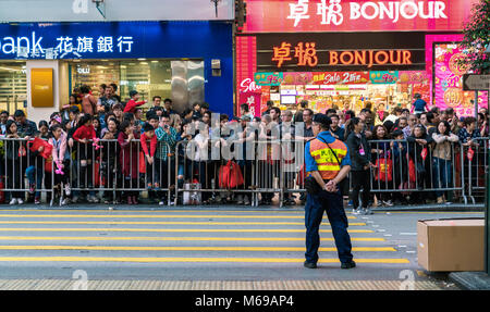16 February 2018 - Hong Kong. People gathering to watch Chinese New Year's parade in Central of Hong Kong. Policeman observing the crowd. Stock Photo